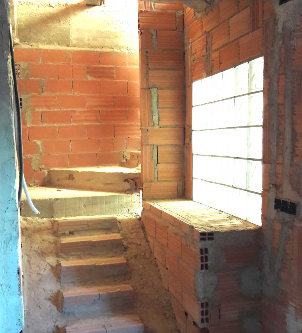 Detalle de construcción de escalera con pared de pavés
